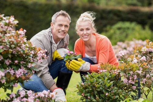 Gardener planting flowers in a well-maintained Earls Court garden